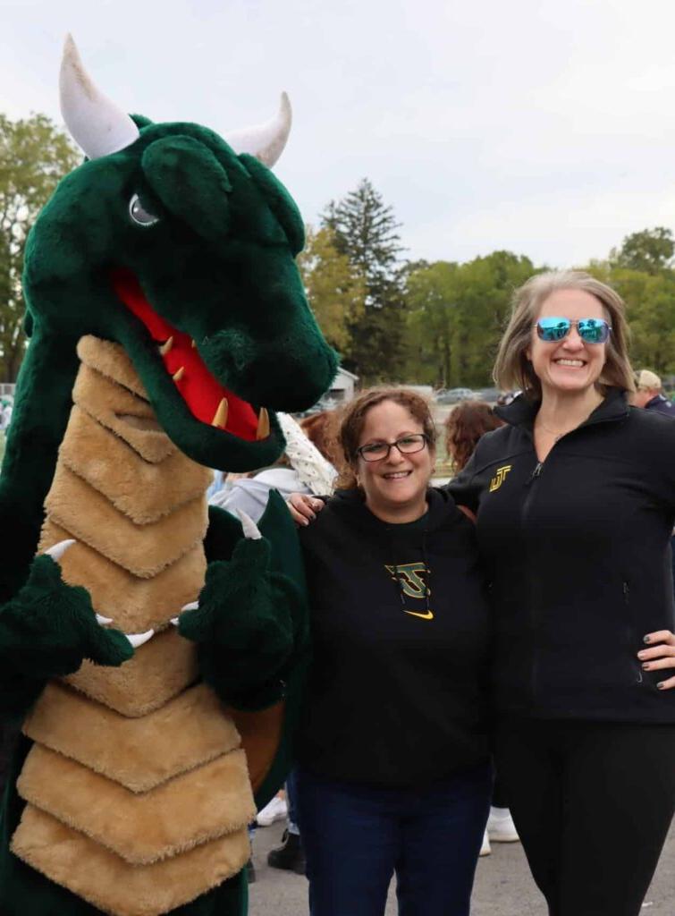 smiling alumni with blaze at football game